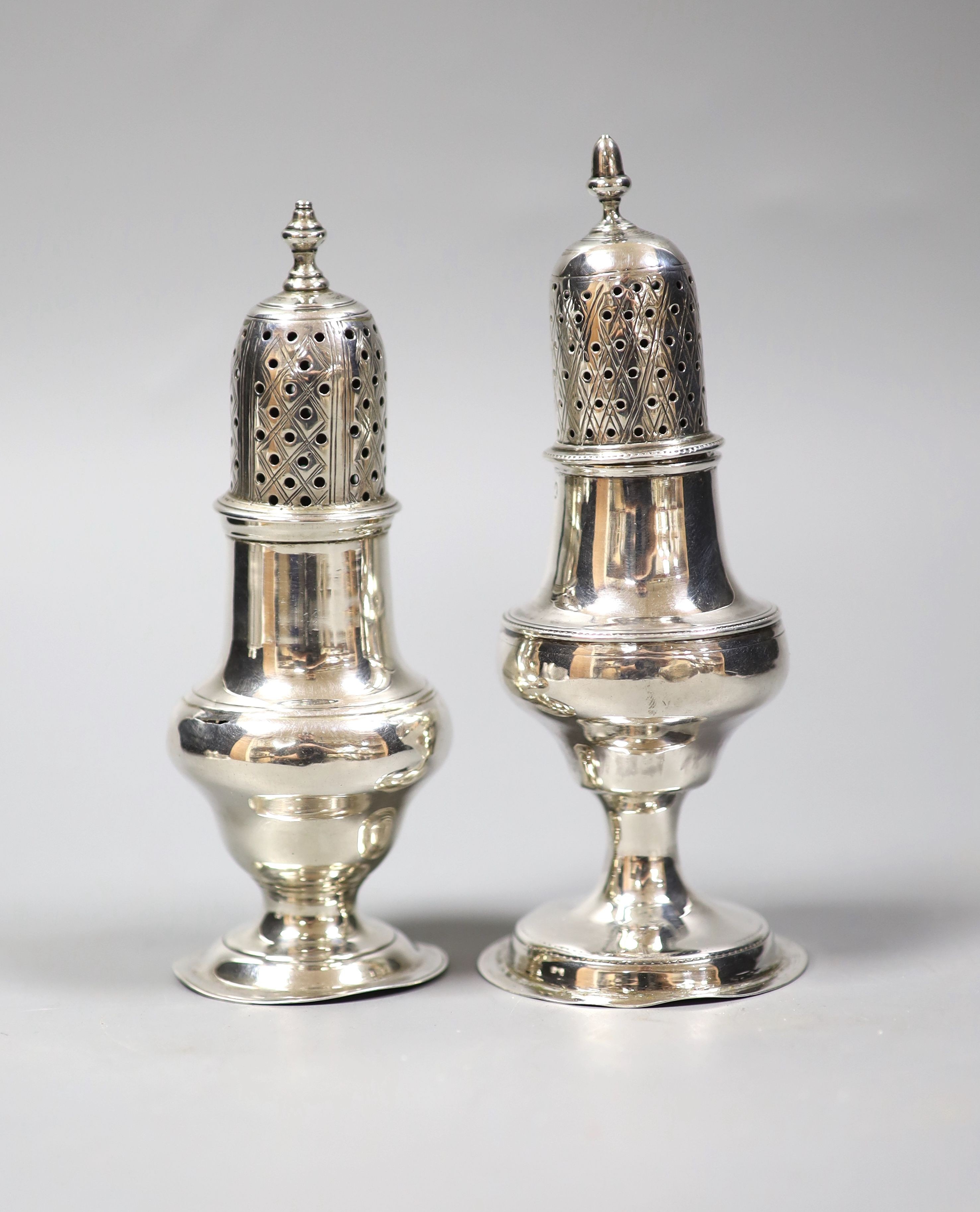 Two Georgian silver pepperettes, London, 1784 and London, 1788, tallest 14.1cm, 149 grams.